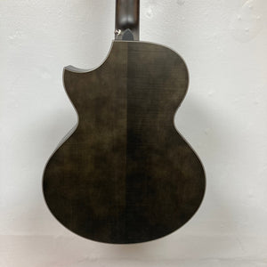 The Schecter Orleans Stage 7-String Acoustic Guitar features a dark matte finish, rounded body, and single upper-left cutaway, shown against a plain white wall.