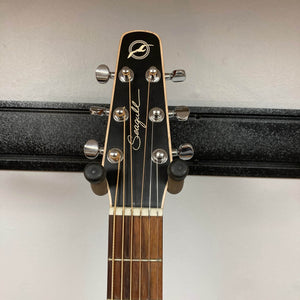 The headstock of a Seagull S6 QI Slim Acoustic Guitar w/Hard Case by Seagull, showing six tuning pegs, is mounted on a black wall hanger.