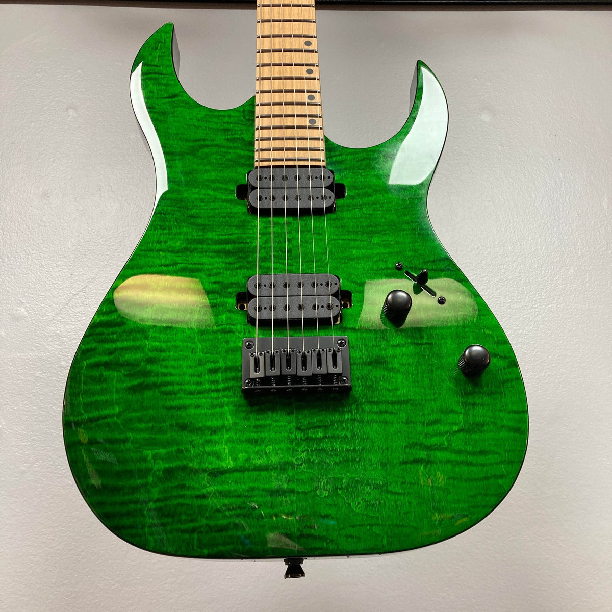 The Spira S-450 Trans Green TGR by Spira features a figured maple top, custom humbuckers, fixed bridge, three black control knobs, and roasted maple neck—an ideal electric guitar for rock and metal, shown on a light backdrop.