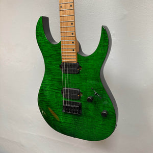 The Spira S-450 Trans Green TGR by Spira is an electric rock and metal guitar with a flamed maple top, custom humbuckers, five-way switch, two control knobs, and roasted maple neck, photographed against a plain white wall.