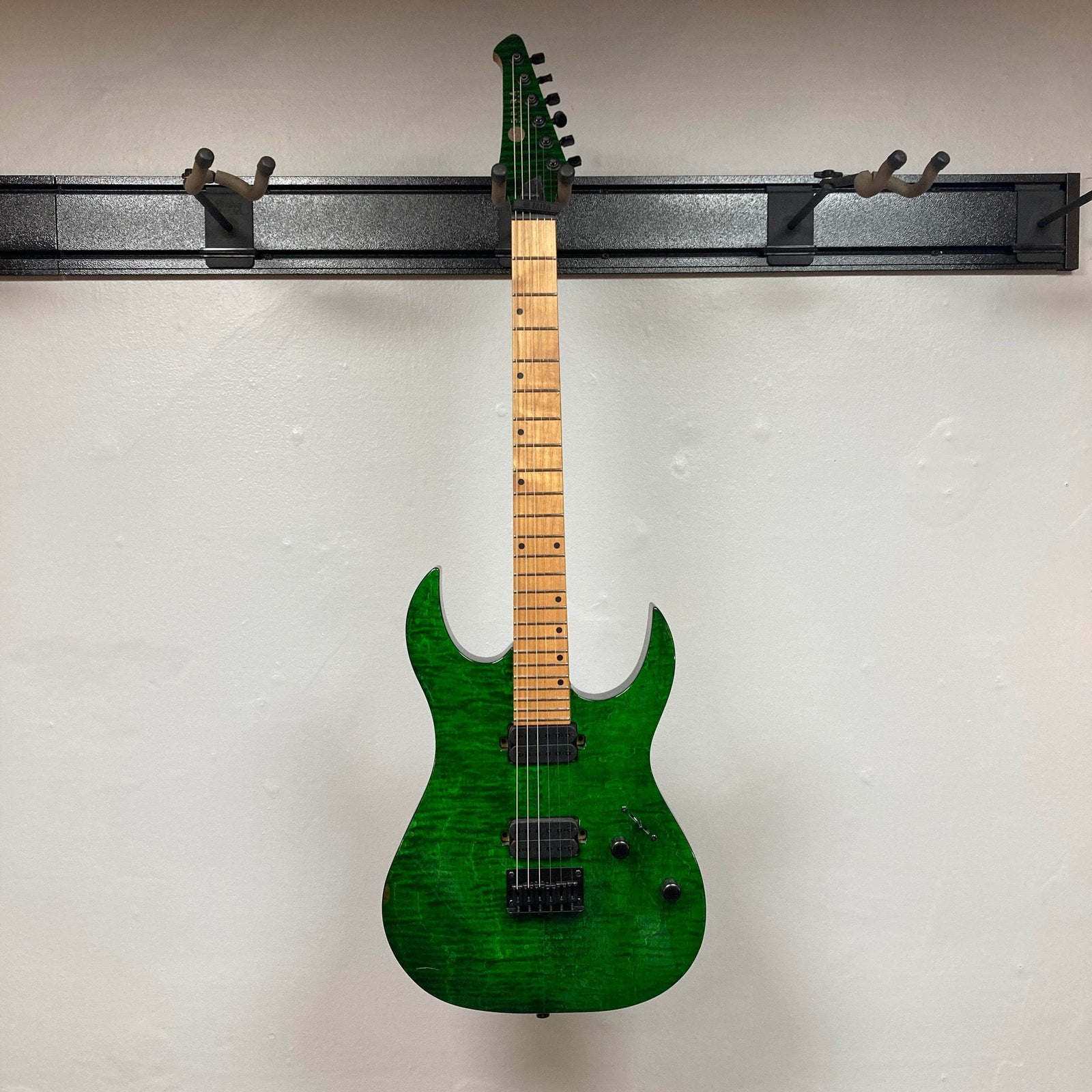 The Spira S-450 Trans Green TGR electric guitar by Spira features a roasted maple neck, black hardware, custom humbuckers, bridge, two control knobs, and a selector switch, shown on a plain white background. The Spira S-450 Trans Green TGR electric guitar by Spira features a roasted maple neck, black hardware, custom humbuckers, bridge, two control knobs, and a selector switch, shown on a plain white background.