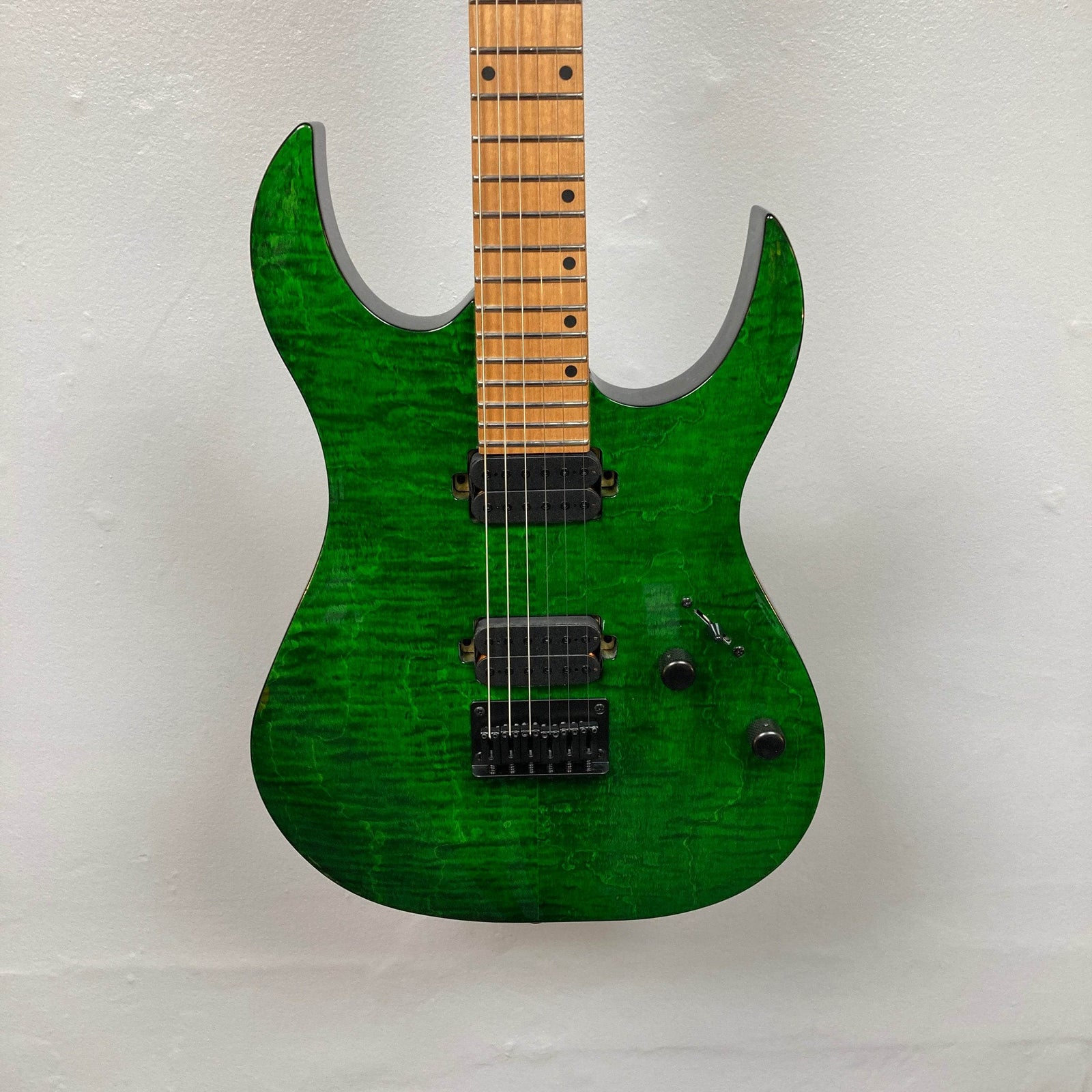 The Spira S-450 Trans Green TGR electric guitar by Spira features a roasted maple neck, black hardware, custom humbuckers, bridge, two control knobs, and a selector switch, shown on a plain white background. The Spira S-450 Trans Green TGR electric guitar by Spira features a roasted maple neck, black hardware, custom humbuckers, bridge, two control knobs, and a selector switch, shown on a plain white background.