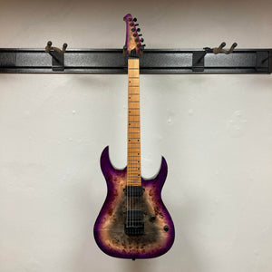A Spira S-450 Trans Purple TPP seven-string electric guitar by Spira, featuring a maple neck with modern D profile and black hardware, hangs on a wall-mounted rack, its purple and wood burst finish contrasting the white wall.