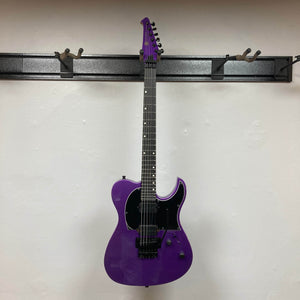 A Spira T-420 PP electric guitar by Spira, featuring a purple finish, black pickguard, six strings, and high-output humbuckers, hangs on a wall-mounted rack against a white wall.