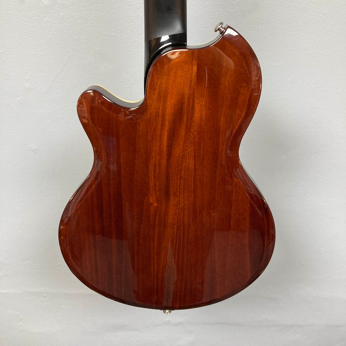 Back view of a glossy Supro 1296 Silverwood British Racing Green electric guitar body with a smooth wooden finish and a dark-colored neck, photographed against a plain white background.
