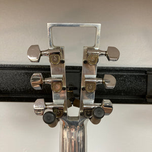 Travis Bean TB1000A Artist Natural 1970s guitar close-up, highlighting aluminum neck and bridge, high-output pickups, and visible wear. Vintage case included.