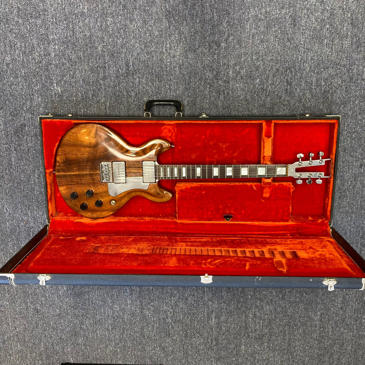 Travis Bean TB1000A Artist Natural 1970s in a vintage red case, showcasing its aluminum neck and original components.