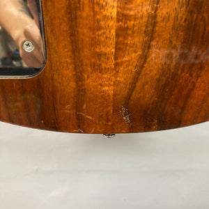 Close-up of a Travis Bean TB1000A guitar, highlighting its wooden body and aluminum neck, showcasing its vintage condition.