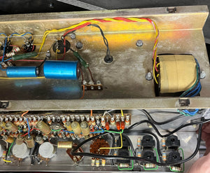 Interior view of a Vintage 1963 Vox AC30/6 Normal by Vox, showing capacitors, resistors, wires, and a Woden transformer inside its metal chassis—similar to classic models, complete with original JMI Egg Footswitch and flight case.