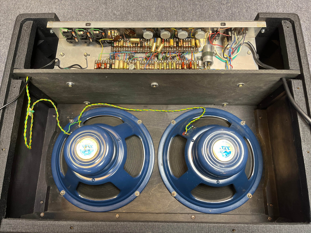 Rear view of a Vintage 1963 Vox AC30/6 Normal by Vox, featuring visible electronic circuitry, control knobs, and two original Celestion Blue T530 speakers inside the cabinet; includes JMI Egg footswitch and flight case.