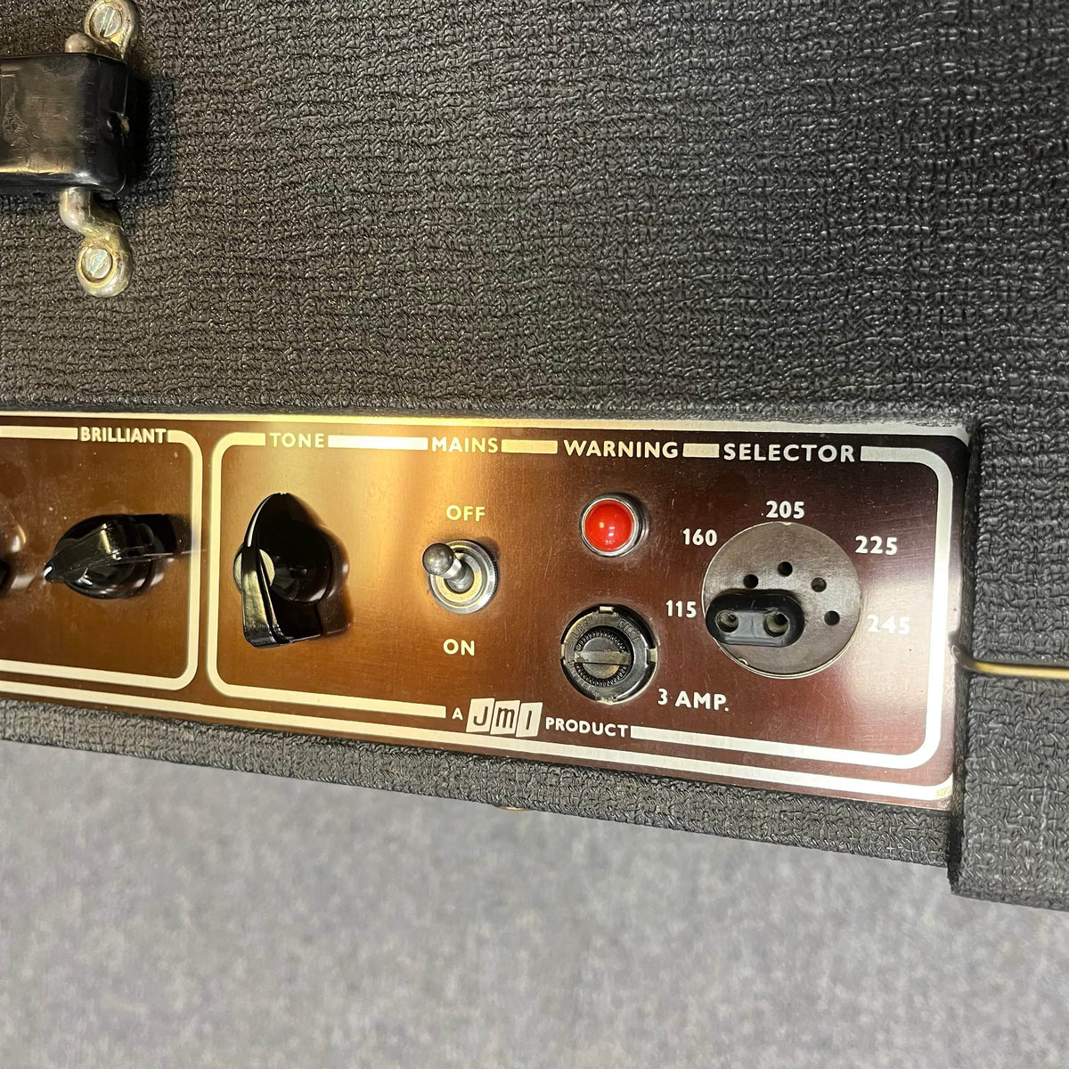 Close-up of a 1963 Vox AC30/6 Normal control panel with original JMI egg footswitch and flight case, showing tone switches, mains on/off, warning light, and voltage selector (115–245V).