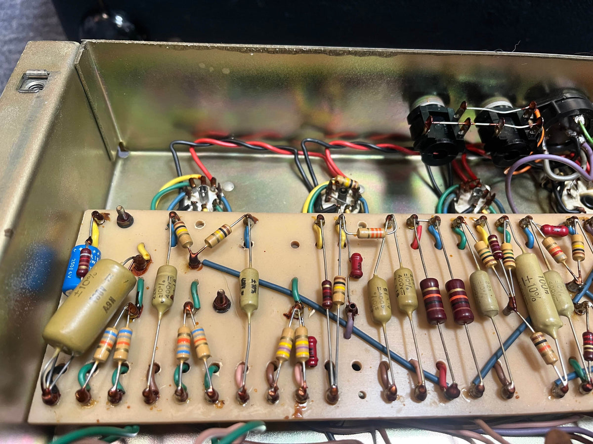 Close-up of an electronic circuit board with resistors, capacitors, and wires inside a metallic enclosure—typical of a vintage Marshall 1971 Lead Head JMP 1987 50 Watt amp, known for its legendary British Grind sound. Includes flight case.