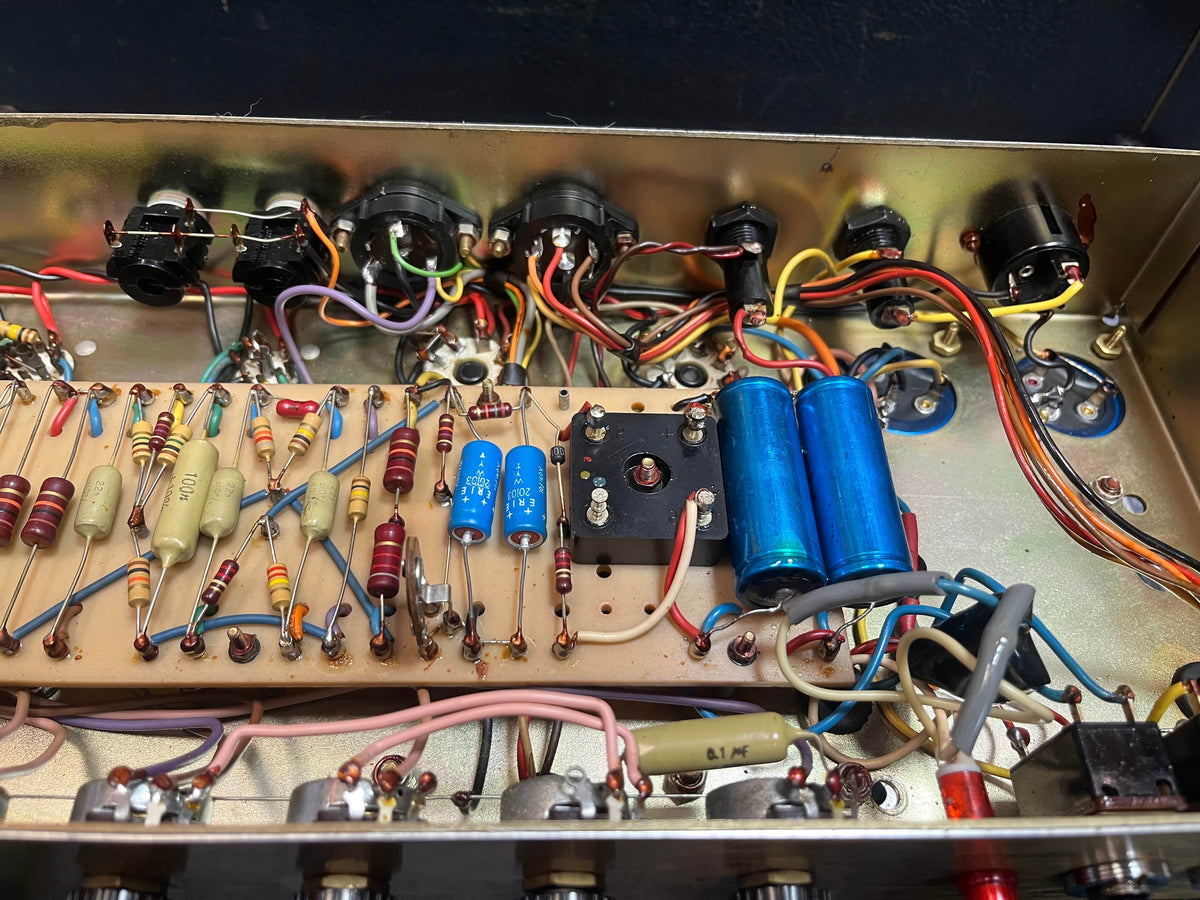 The image displays the internal wiring and components, such as resistors and capacitors, inside a Marshall 1971 50W Lead Head JMP Era amp, complete with flight case, known for its classic British Grind.