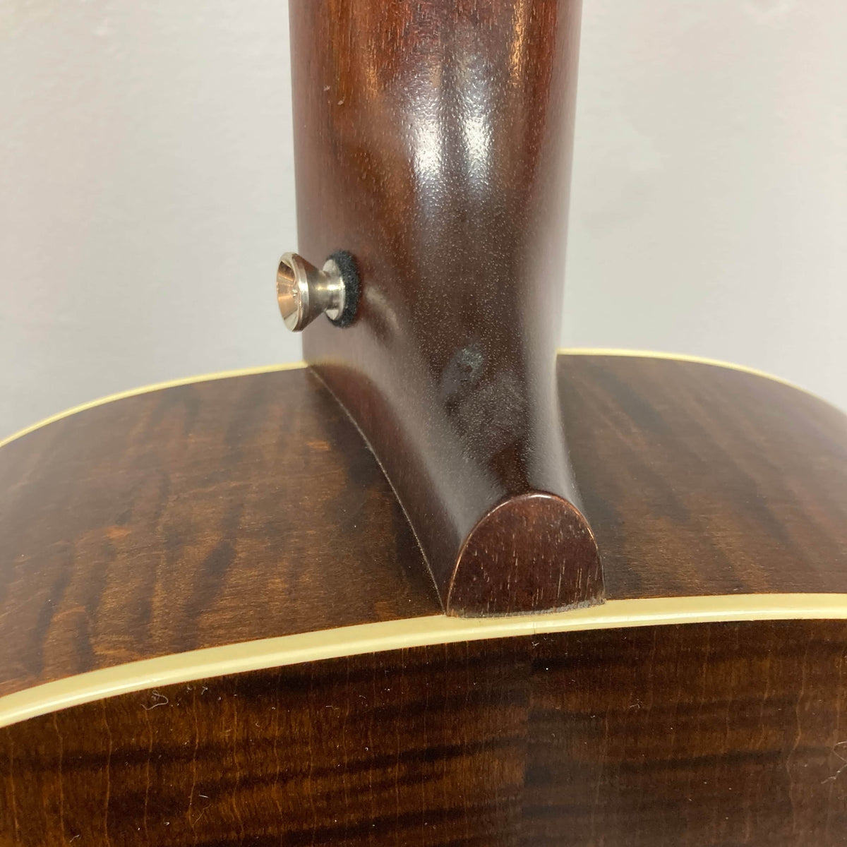 Close-up of the neck joint on this used Waterloo WL-12 Parlor Acoustic w/Case shows the strap button on the heel and cream body binding, highlighting classic vintage craftsmanship by Waterloo.