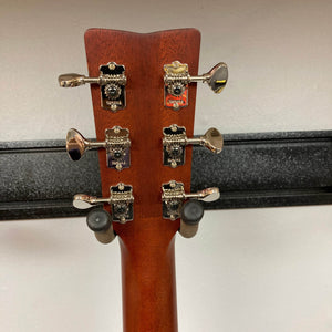 Close-up of the Yamaha FSX5 Satin Red Label Natural Made in Japan acoustic-electric guitar headstock, featuring six chrome tuning pegs on a dark brown neck, shown against a plain white wall.