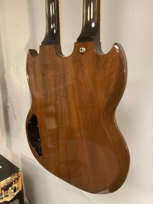 1980 Gibson EDS-1275 Double Neck Electric Guitar hanging on a wall, showcasing its dual necks and vintage design.