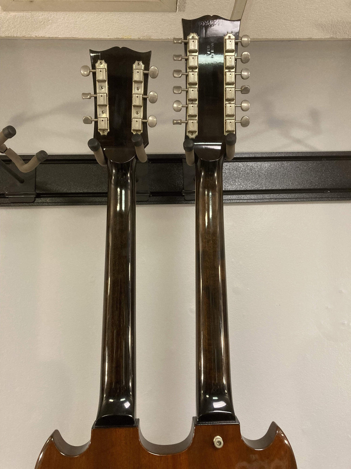 1980 Gibson EDS-1275 Double Neck Electric Guitar hanging on a wall.