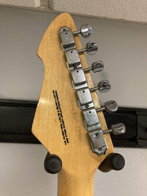 1980 Peavey T-27 Electric Guitar close-up, showcasing its double-cutaway body, maple neck, and high gloss finish with b/w/b pickguard, highlighting vintage charm and versatility.