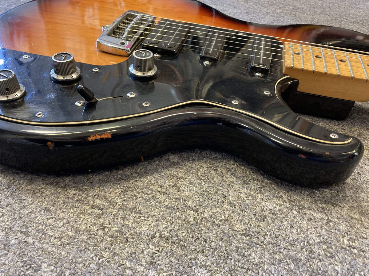 Close-up of the 1980 Peavey T-27 Electric Guitar, showcasing its double-cutaway body, control knobs, and high gloss finish.