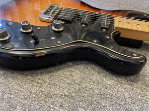 Close-up of the 1980 Peavey T-27 Electric Guitar, showcasing its double-cutaway body, control knobs, and high gloss finish.