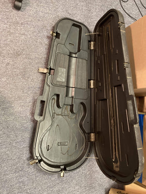 1980 Peavey T-27 Electric Guitar in a black case with visible scratches, reflecting its vintage charm and history.