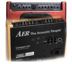 Close-up of AER Compact 60/4 OMH Stained Oak amplifier, showcasing control knobs and input jacks for acoustic instruments. Ideal for stage, studio, and home use.