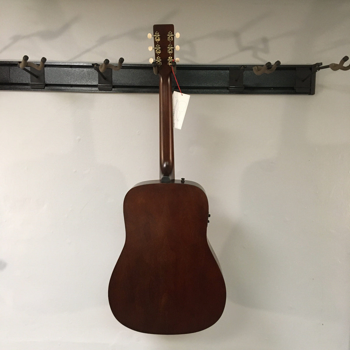 Art & Lutherie Americana Bourbon Burst guitar on display, showcasing its acoustic-electric features with integrated electronics and rosewood fingerboard, made for versatile performances.