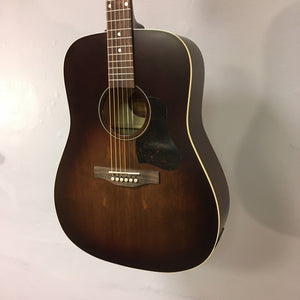 Art & Lutherie Americana Bourbon Burst Presys II guitar on a wall, showcasing its detailed craftsmanship and design.