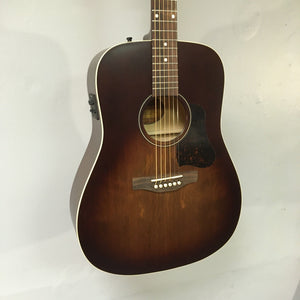 Art & Lutherie Americana Bourbon Burst Acoustic-Electric Guitar mounted on a wall, showcasing its strings and craftsmanship.