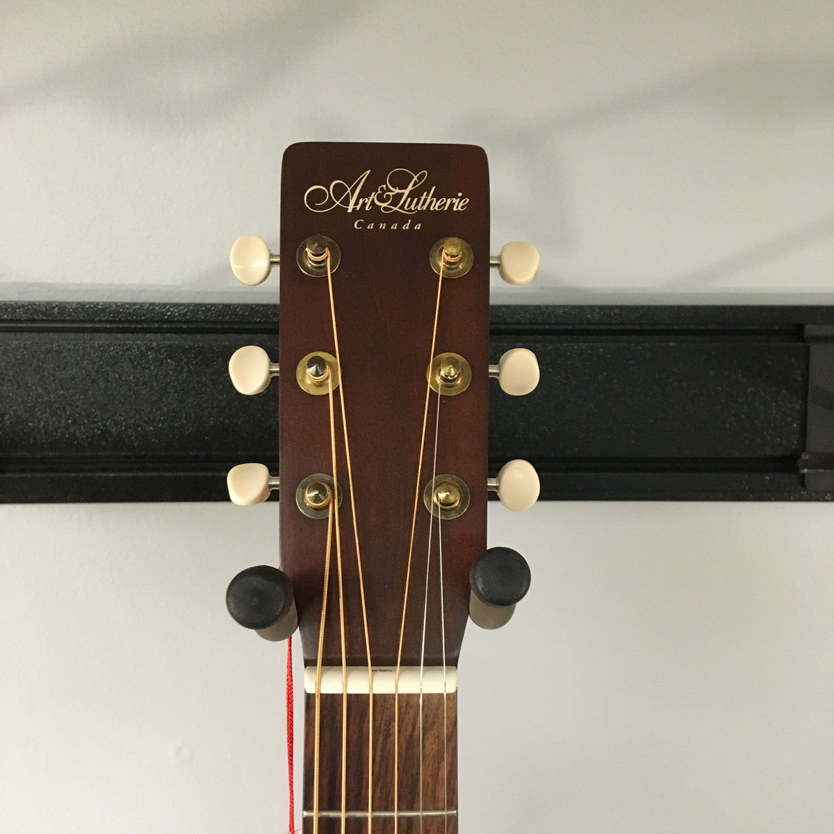 Close-up of the Art & Lutherie Americana Bourbon Burst Acoustic-Electric Guitar head, strings, and tuning pegs, showcasing its craftsmanship and high-quality components.