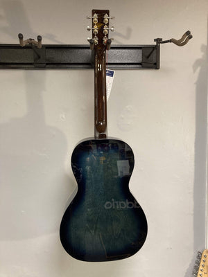 Rear view of the Art & Lutherie Roadhouse HG Indigo Burst Q-Discrete parlor guitar, featuring a solid spruce top, hanging on a wall rack with a price tag on the headstock.