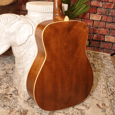 Bodhi BG10S Solid Spruce Top Concert Body Acoustic Guitar on a table, highlighting its compact design and superior tonal quality.