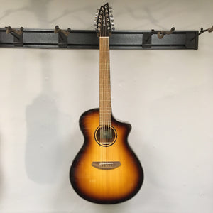 Breedlove Discovery S Concert CE 12-string Edgeburst guitar, mounted on a wall, showcasing its strings and body features.
