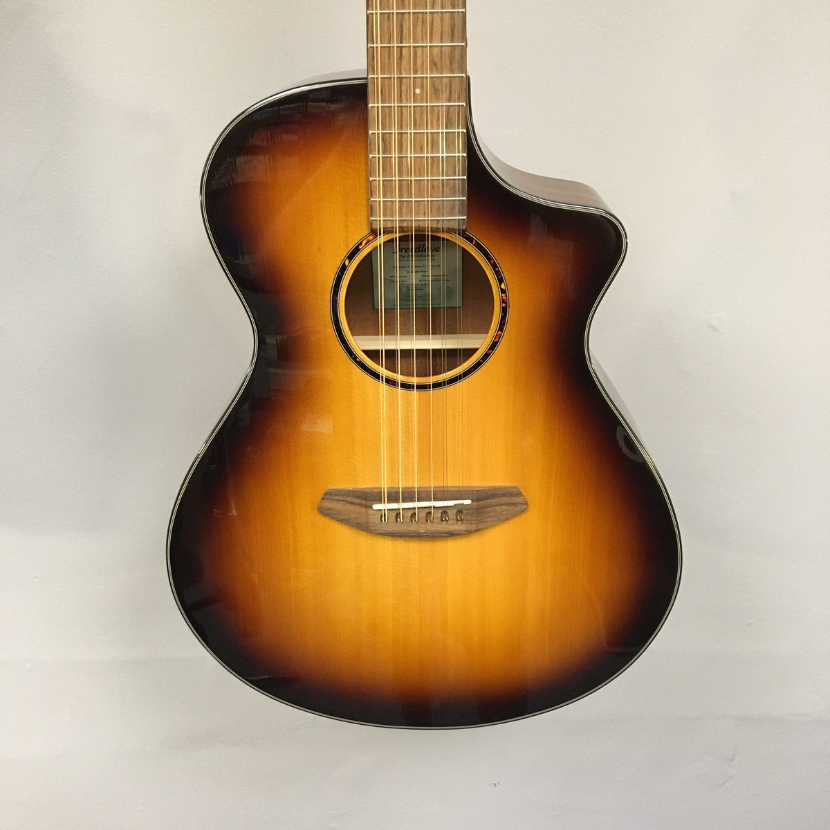 Close-up of a Breedlove Discovery S Concert CE 12-string Edgeburst acoustic guitar, highlighting the strings and body finish.