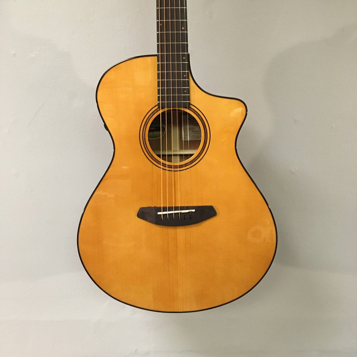 Close-up of Breedlove Performer Pro Concert guitar with European spruce top and African mahogany body, showcasing strings and craftsmanship.