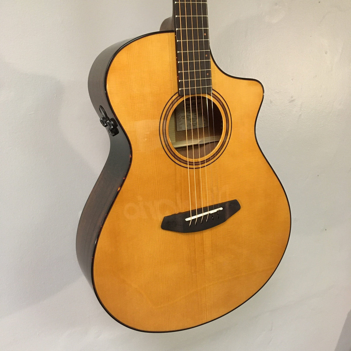 Breedlove Performer Pro Concert Aged Toner CE guitar displayed on a wall, showcasing its European spruce top and African mahogany body.