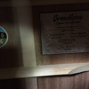 Close-up of a Breedlove Performer Pro Concerto Aged Toner guitar label inside the body, showing model info, serial number, wood types, and a "Made in Bend, Oregon, USA" sticker—emphasizing its rich acoustic tone and Gator Gigbag.