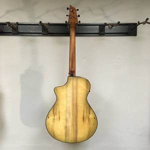 Breedlove Pursuit Exotic S Concert Sweetgrass CE B-Stock acoustic guitar mounted on a wall, highlighting its detailed craftsmanship and elegant design.