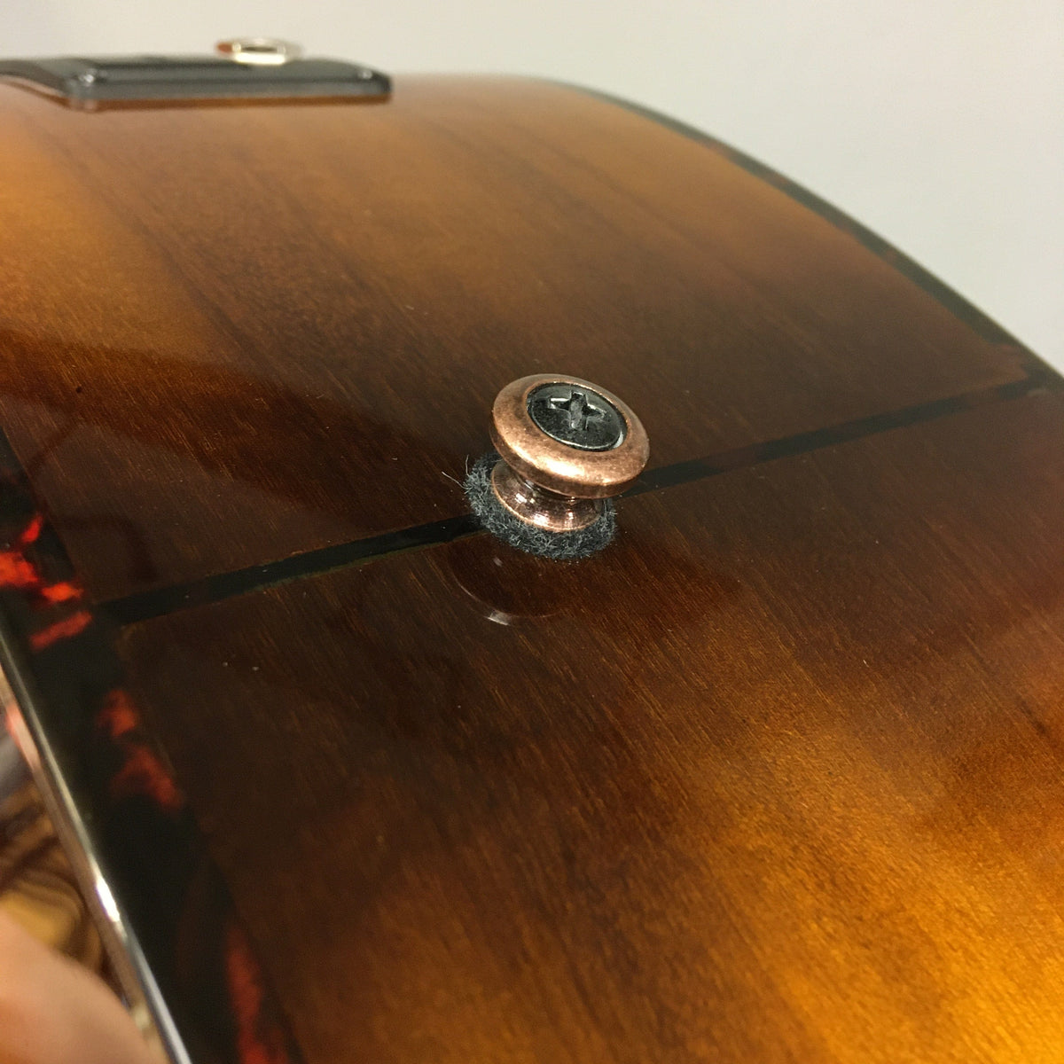 Close-up of Breedlove Pursuit Exotic S Concerto CE Tiger's Eye Myrtlewood B-Stock acoustic guitar, highlighting the tortoise-bound finish and visible blemishes on the binding.