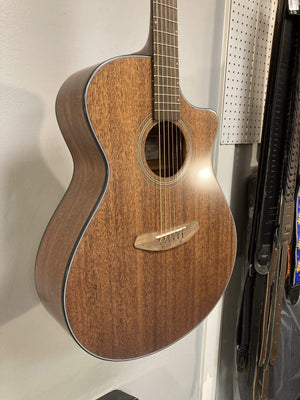 Breedlove Wildwood Concerto Satin CE Solid African Mahogany guitar displayed on a wall.