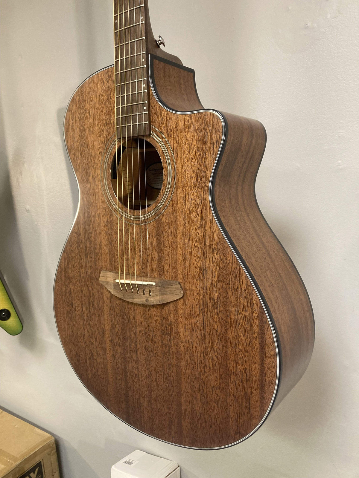 Breedlove Wildwood Concerto Satin CE guitar, close-up of solid African mahogany body and strings, highlighting craftsmanship and detail.
