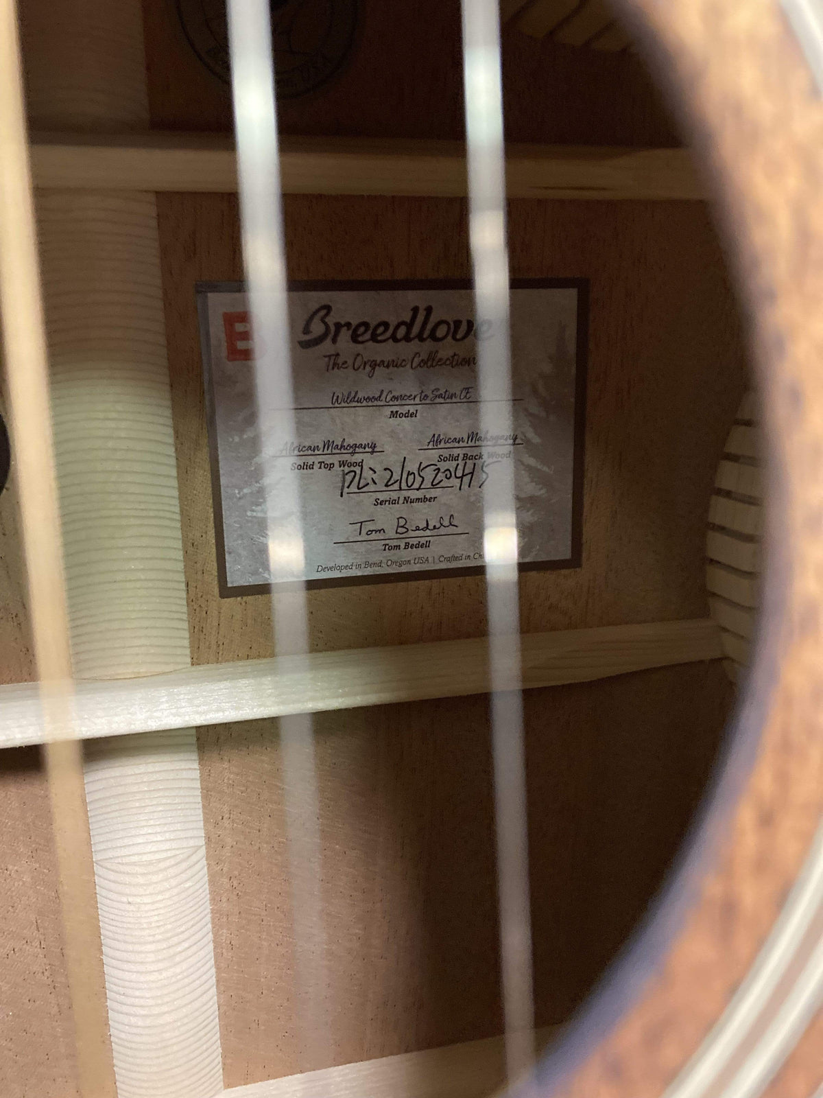 Close-up of Breedlove Wildwood Concerto Satin CE guitar, showcasing its solid African mahogany body and intricate craftsmanship.