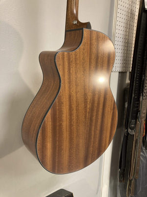 Breedlove Wildwood Concerto Satin CE Solid African Mahogany guitar displayed on a wall, highlighting its straight grain and soft cutaway design.