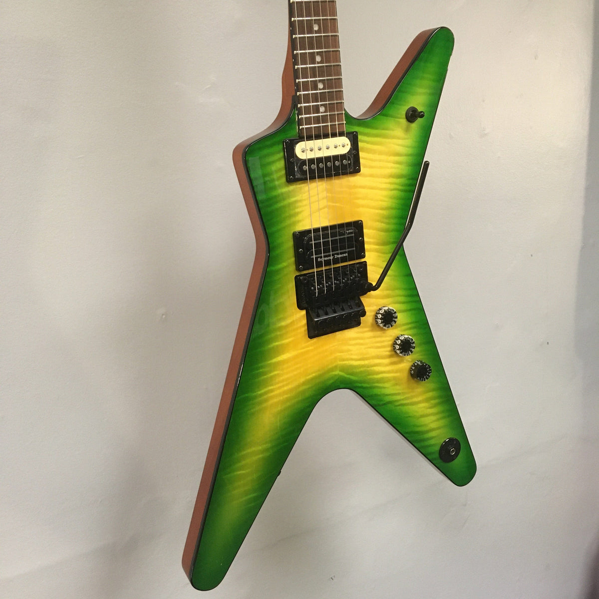 Dean Dimebag Dime Slime ML electric guitar mounted on a wall, featuring a distinctive design with premium pickups and Floyd Rose tremolo bridge.