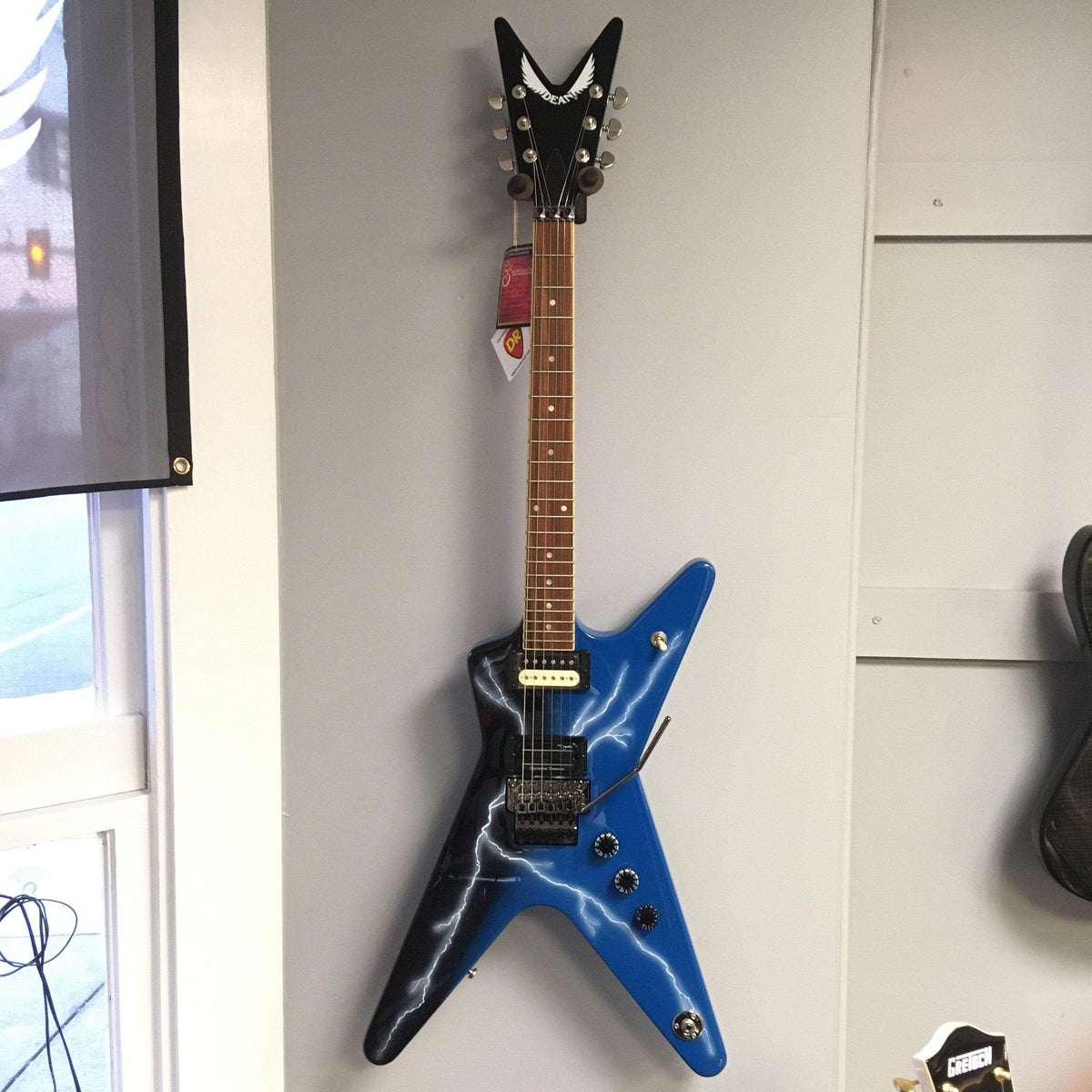 Dean Dimebag From Hell ML electric guitar with unique graphic, set mahogany neck, and Floyd Rose Special bridge, displayed on a wall.