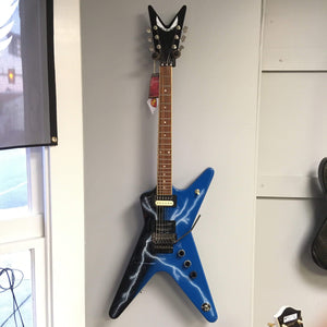 Dean Dimebag From Hell ML electric guitar with unique graphic, set mahogany neck, and Floyd Rose Special bridge, displayed on a wall.