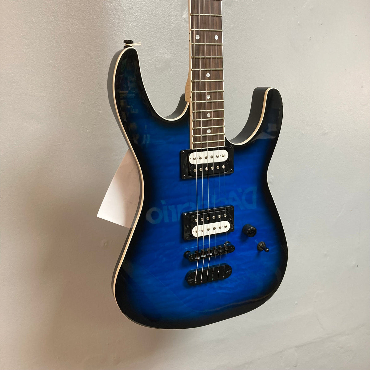 Dean MD X Quilt Maple Trans Blue Burst electric guitar, featuring 22 frets, zebra pickups, and a quilted maple top, displayed on a wall.