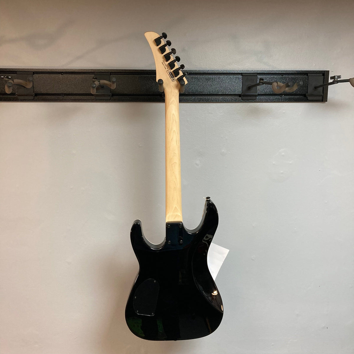 Dean MD X Quilt Maple Trans Blue Burst electric guitar with a 22-fret maple neck, Indian rosewood fingerboard, and high-output zebra pickups, mounted on a wall.