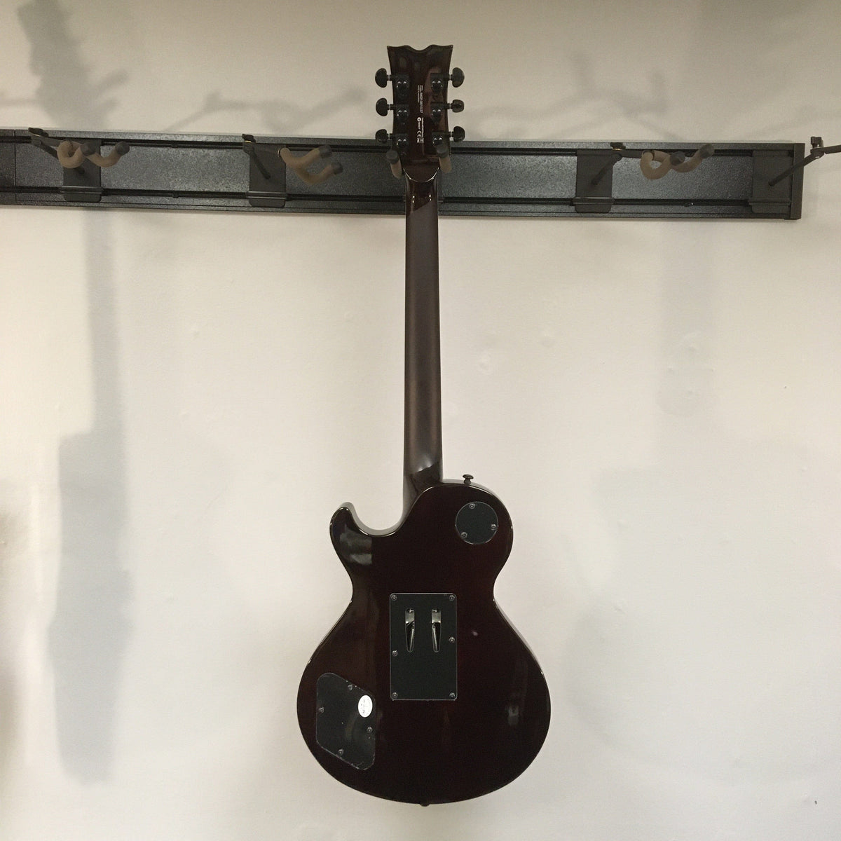 Dean Thoroughbred Select Quilt-top guitar with Floyd Rose bridge, Seymour Duncan pickups, and satin-finished neck, mounted on a display wall.