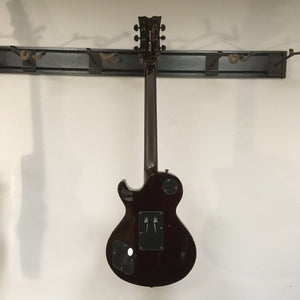 Dean Thoroughbred Select Quilt-top guitar with Floyd Rose bridge, Seymour Duncan pickups, and satin-finished neck, mounted on a display wall.